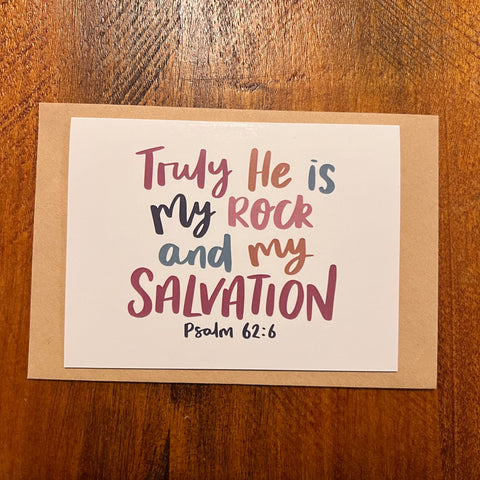 Card with 'Truly He is My Rock and My Salvation' text on a wooden surface
