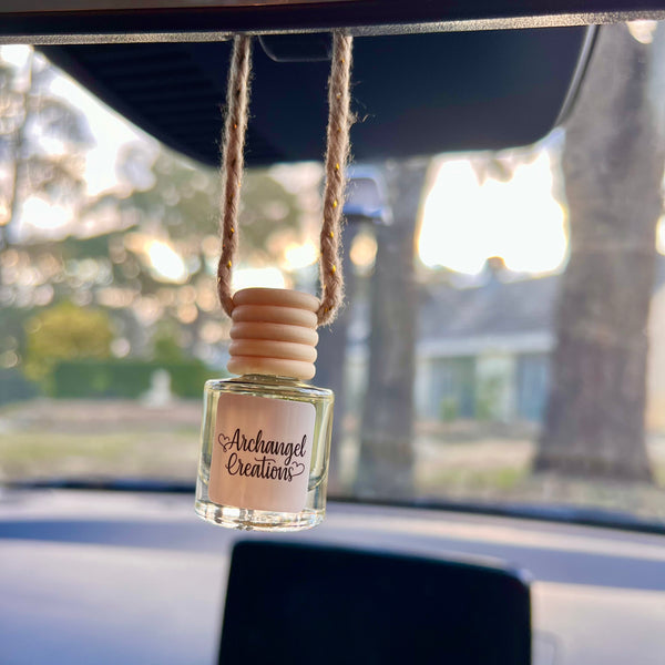 Car air freshener hanging from a car's rearview mirror with 'Archangel Creation' branding.