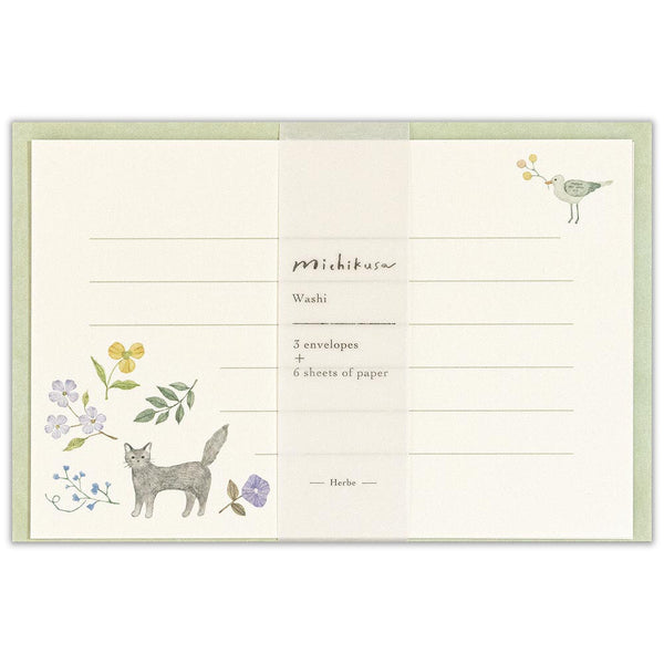 Stationery set with illustrations of a cat, flowers, and a bird on a white background